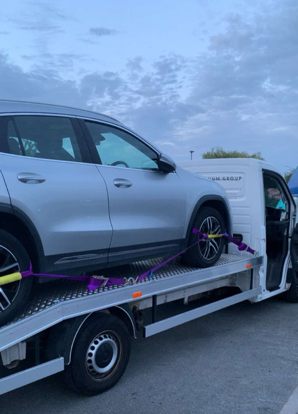 An SUV secured with wheel straps on the MPG Recovery truck bed